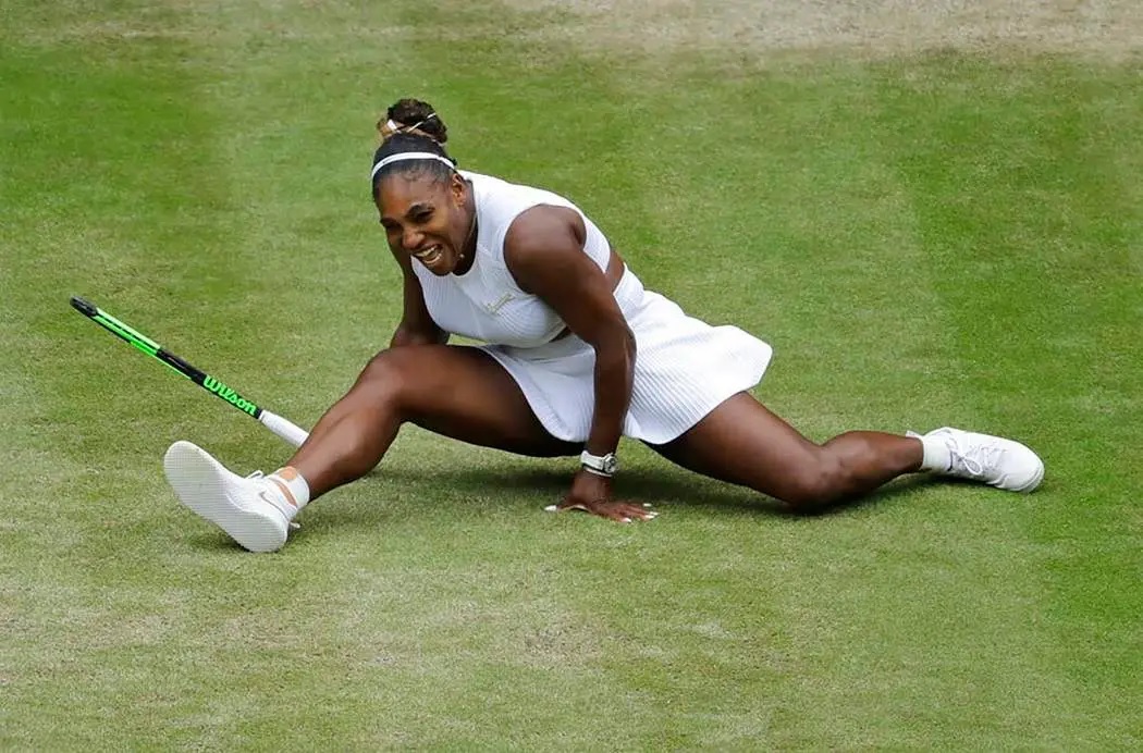 Serena Williams does the splits after playing a return